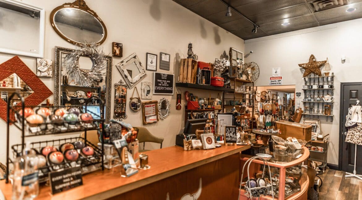 Interior of a retail store with holiday decorations and gift items on shelves and tables.